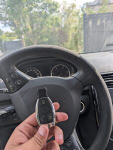 Clé Mercedes Classe A neuve tenue devant le volant après programmation en perte totale